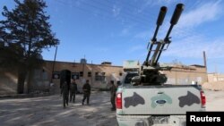 Fighters from the Democratic Forces of Syria walk outside a prison which they say belonged to Islamic State fighters, in al-Shadadi town, Hasaka province, Syria, Feb. 26, 2016.