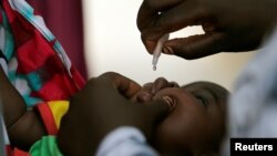 FILE - A child is given a dose of polio vaccine at an immunisation health center, in Maiduguri, Borno state, Nigeria, Aug. 29, 2016. 