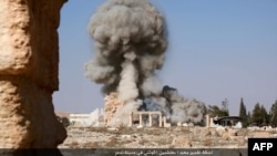 An undated image, which appears to be a screenshot from a video and which was published by the IS group in the Homs province on Aug. 25, 2015, allegedly shows smoke billowing from the Baal Shamin temple in in Syria's ancient city of Palmyra.