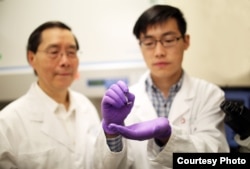 James Lee, Ph.D., left, examines a silicone chip with Junfeng Shi at The Ohio State University College of Engineering. Lee, who led a team of engineers who designed the chip, collaborated with Ohio State Wexner Medical Center on this study to reprogram skin cells to become other types of cells. (Photo courtesy of The Ohio State University Wexner Medical Center)