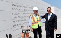 FILE - Actor Gary Sinise, right, talks with Arthur H. Wilson, co-founder of the Disabled Veterans' Life Memorial Foundation, Inc., left, as they tour the new American Veterans Disabled For Life Memorial in Washington, Aug. 20, 2014.