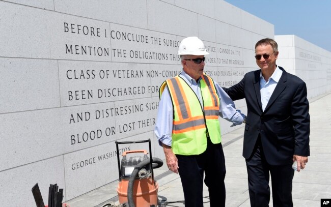 FILE - Actor Gary Sinise, right, talks with Arthur H. Wilson, co-founder of the Disabled Veterans' Life Memorial Foundation, Inc., left, as they tour the new American Veterans Disabled For Life Memorial in Washington, Aug. 20, 2014.