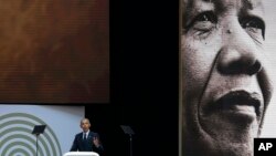 U.S. President Barack Obama, at podium delivers his speech at the 16th Annual Nelson Mandela Lecture at the Wanderers Stadium in Johannesburg, South Africa, July 17, 2018.