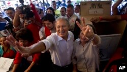Vice President Salvador Sanchez, presidential candidate for the ruling Farabundo Marti National Liberation Front (FMLN) and his wife Margarita Villalta pose for photos after voting at a polling station in San Salvador, El Salvador, Feb. 2, 2014.