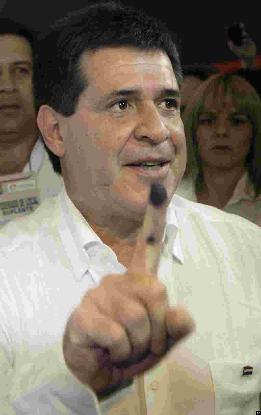 Paraguay&#39;s Colorado Party&#39;s Presidential candidate Horacio Cartes shows his ink-marked finger after voting in Goethe School, Asuncion, Paraguay, April 21, 2013.