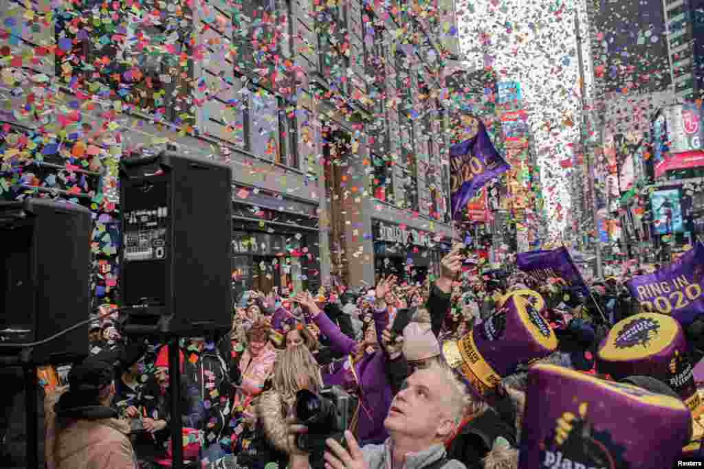 Orang-orang menyaksikan lemparan confetti dari tenda Hard Rock Cafe selama tes confetti tahunan menjelang perayaan pesta Tahun Baru di Times Square, New York.