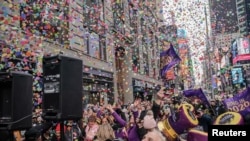 People watch confetti as it's thrown from the Hard Rock Cafe marquee as part of the annual confetti test ahead of the New Year's Eve ball-drop celebrations in Times Square in New York City, New York, U.S., December 29, 2019. 