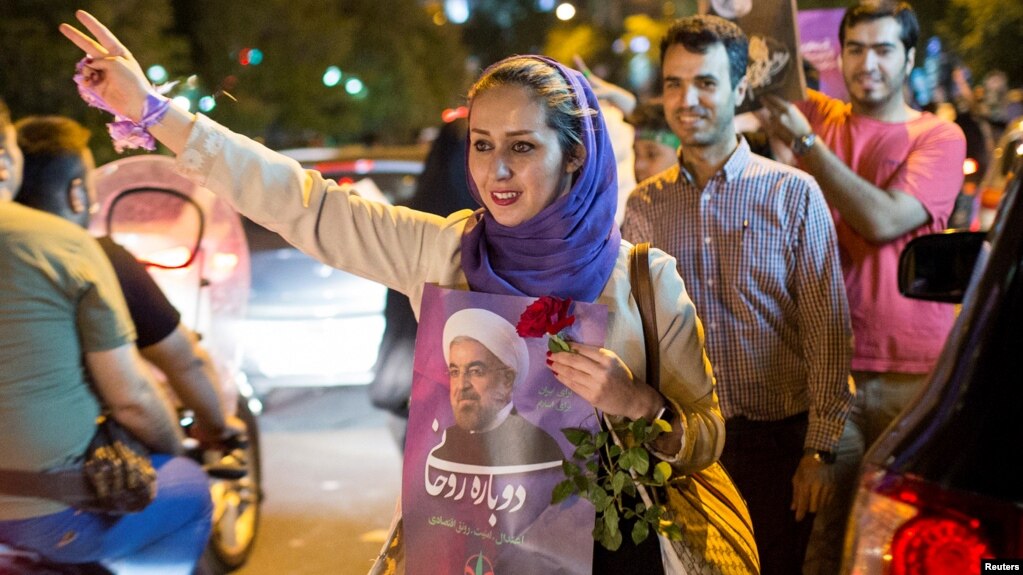 A woman holds a poster of Iranian President Hassan Rouhani during a campaign rally in Tehran, Iran, May 17, 2017. 