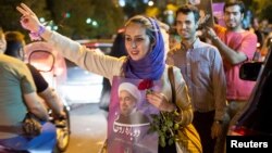 A woman holds a poster of Iranian President Hassan Rouhani during a campaign rally in Tehran, Iran, May 17, 2017. 