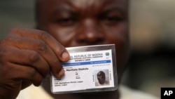 Muritala Diekola, display his new voters registration card in Lagos, Nigeria, Saturday, Jan. 15, 2011. An effort to register 70 million voters across Nigeria before its April presidential election wobbled to a start Saturday, as volunteers fought with mal