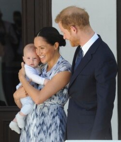 Pangeran Harry dan Meghan dari Inggris, Duchess of Sussex, menggendong putra mereka Archie, di Cape Town, Afrika Selatan. (Foto: AP)