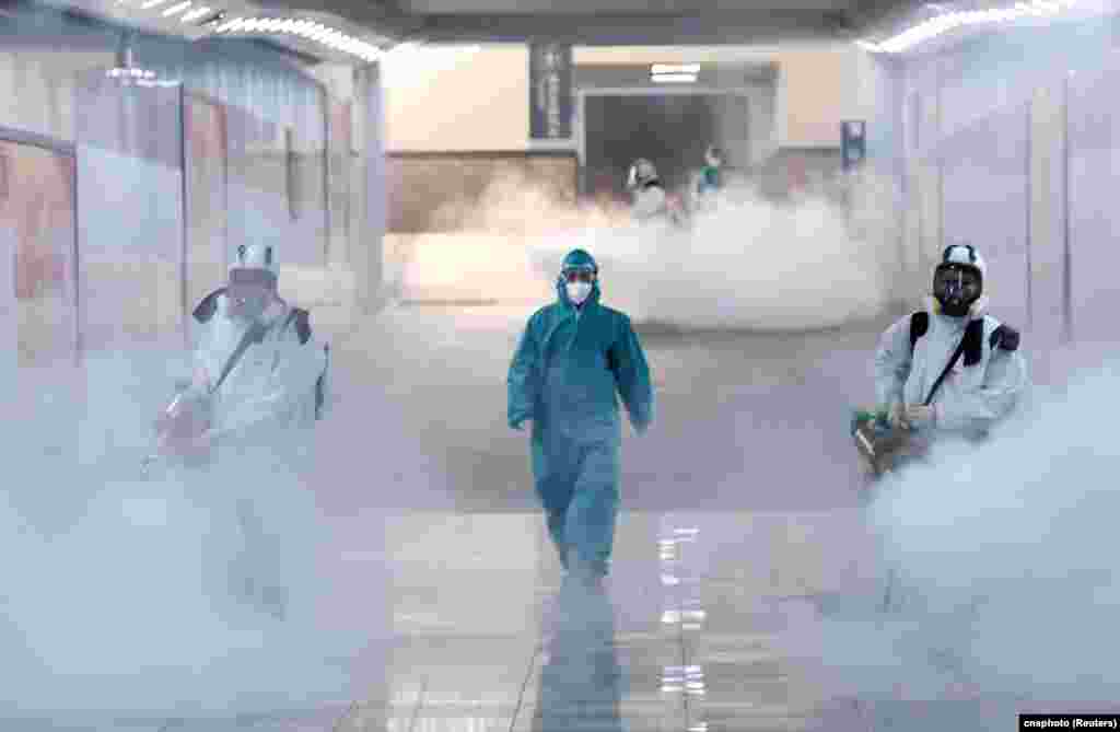 Volunteers in protective suits disinfect a railway station as the country is hit by an outbreak of the new coronavirus, in Changsha, Hunan province, China.