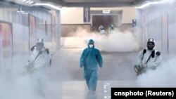 Volunteers in protective suits disinfect a railway station as the country is hit by an outbreak of the new coronavirus, in Changsha, Hunan province, China February 4, 2020. 