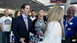 Democratic congressional candidate Mike Levin talks with his wife, Chrissy Levin, in front of supporters at the 2018 California Democrats State Convention, Feb. 24, 2018, in San Diego. "Many voters are looking for someone who will be a check [on the administration] and not just a rubber stamp," he said. Levin is seeking the open seat in California's 49th District. 