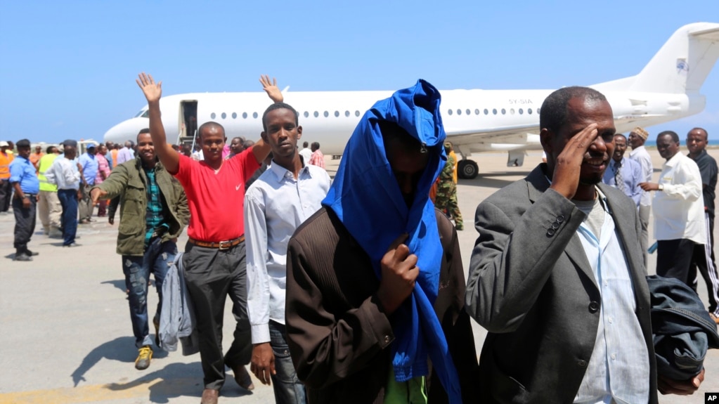 FILE- Deported Somali nationals gesture as they arrive at the airport in Somalia's capital of Mogadishu, April 9, 2014. Sixty-eight Somalis arrived in Mogadishu Friday, having been deported by U.S. immigration authorities.