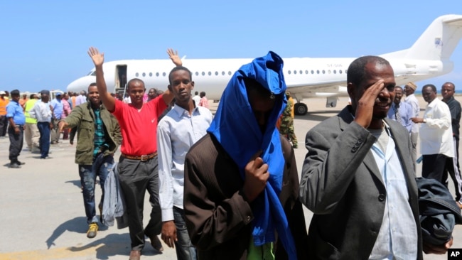 FILE- Deported Somali nationals gesture as they arrive at the airport in Somalia's capital of Mogadishu, April 9, 2014. Sixty-eight Somalis arrived in Mogadishu Friday, having been deported by U.S. immigration authorities.