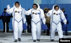 ບັນດາສະມາຊິກ ຂອງສະຖານີອະວະກາດສາກົນ ຫຼື International Space Station (ISS) ພາລະກິດ 54/55, ໂດຍມີ ນັກເຫາະຈັກກະວານ ຂອງ Roscosmos ທ່ານ ແອນຕັນ ສກາເປລີຣອບວ໌ (Anton Shkaplerov), ກາງ, ນັກບິນອະວະການດ ຂອງອົງການ ນາຊາ (NASA) ທ່ານ ສກອດ ທິນໂກ (Scott Tingle), ຂວາ, ແລະ ທ່ານ ໂນຣີຊີເກ ຄານາອິ (Norishige Kanai) ຂອງອົງການຄົ້ນຄ້ວາ ອະວະກາດ ຂອງຍີ່ປຸ່ນ, ຊ້າຍ ໃນລະຫວ່າງ ພິທີການສົ່ງອອກ