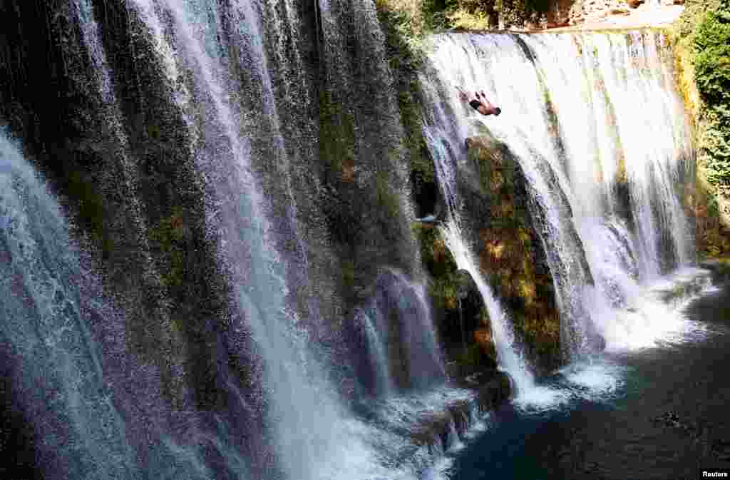 A competitor takes part in the annual international waterfall jumping competition held in the old town of Jajce, Bosnia and Herzegovina, Aug. 5, 2017.