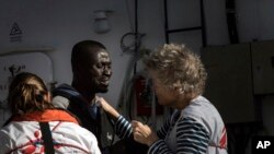 FILE: A migrant reacts as he is greeted by MSF workers aboard the MV Aquarius, as 193 people and two corpses are recovered, Jan. 13, 2017, from international waters in the Mediterranean Sea about 35 Km north of Sabrata, Libya. 