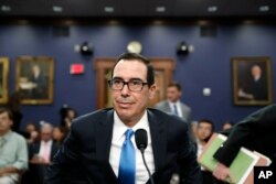 FILE - Treasury Secretary Steven Mnuchin takes his seat to testify at a House Appropriations subcommittee hearing on the budget on Capitol Hill, June 12, 2017.