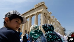 지난 9일 그리스에 입국한 아프가니스탄 난민들이 그리스 문화부가 주선한 관광여행 중 아테네 파르테논 신전을 구경하고 있다. (자료사진)