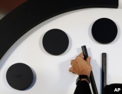 Robert Rosner, chairman of the Bulletin of the Atomic Scientists, moves the minute hand of the Doomsday Clock to two minutes to midnight during a news conference at the National Press Club in Washington, Jan. 25, 2018.