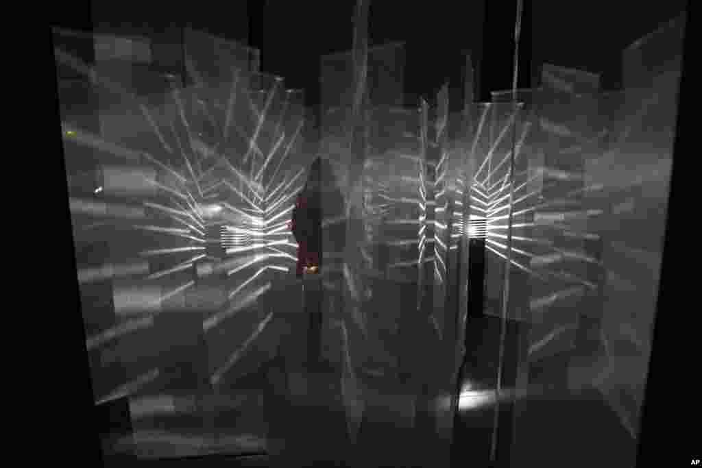 Một nhà báo đi ngang qua Vibration Lumineuse, tác phẩm của nghệ sĩ Julio Le Parc người Argentina, trước giờ khai mạc cuộc triển lãm của ông tại Paris.