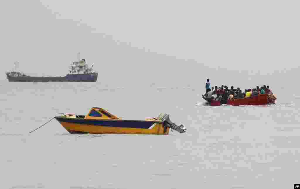 A boat carries people from a ship to shore, before the expected landfall of tropical storm Mora in Chittagong, Bangladesh.