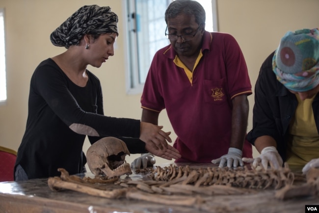 Valeska Martinez, left, and her colleagues analyze human remains — which appear to have suffered a gunshot wound to the head — in a lab in Berbera, Somaliland. (J. Patinkin/VOA)