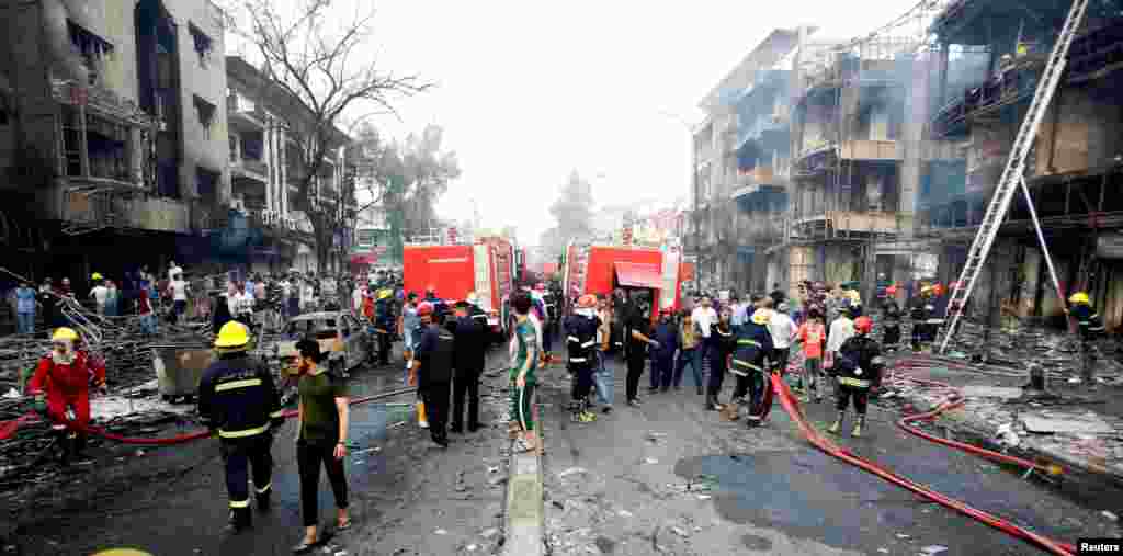 People gather at the site of a suicide car bomb in the Karrada shopping area July 3, 2016.