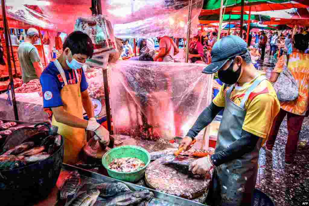 Vendors clean fish at Khlong Toei Market, the biggest fresh market in Bangkok, Thailand.