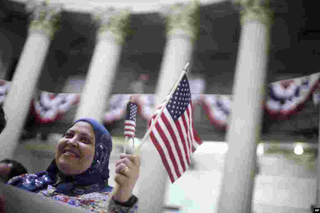 Fatma Atia, yang berasal dari Mesir dan tinggal di New York, melambaikan bendera Amerika dalam sebuah upacara naturalisasi di Balai Federal, New York, 22 Maret 2013.&nbsp;(AP/Mary Altaffer)