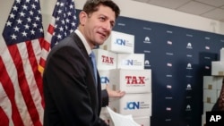 Speaker of the House Paul Ryan, R-Wis., points to boxes of petitions supporting the Republican tax reform bill as he arrives for a news conference on Capitol Hill in Washington, Nov. 14, 2017. 