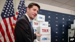 Speaker of the House Paul Ryan, R-Wis., points to boxes of petitions supporting the Republican tax reform bill that is set for a vote later this week as he arrives for a news conference on Capitol Hill in Washington, Nov. 14, 2017. 