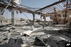 A Yemeni man stands on the rubble of a petrol station after it was hit by Saudi-led airstrikes in Sanaa, Yemen, Sunday, May 27, 2018.