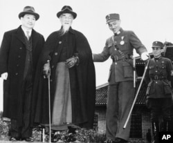 FILE - Generalissimo Chiang Kai-Shek (right center) jovially but respectfully assists China?s President Lin Sen to steps from convention hall after former?s speech to China Youth Corps leaders on May 12, 1943.
