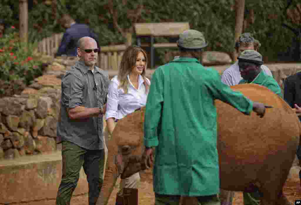Telohranitelji stižu u pomoć dok slonče odgurkuje Melaniju dok ga je potapšala po glavi. "Incident" se dogodio u sirotištu za slonove i nosoroge u Najrobiju u Keniji. 