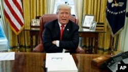 In this Dec. 22, 2017, file photo, President Donald Trump speaks with reporters after signing the tax bill and continuing resolution to fund the government, in the Oval Office of the White House in Washington.