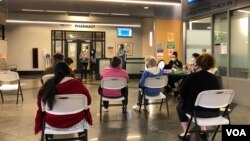 资料照片：在马里兰州巴尔的摩的约翰霍普金斯门诊中心，人们接种了第二剂辉瑞新冠疫苗后坐在观察区内。(2021年5月1日)