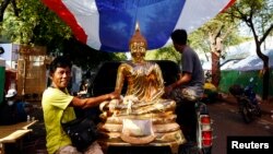Những người biểu tình chống chính phủ vận chuyển một bức tượng Phật bằng vàng tại trung tâm Bangkok, ngày 23/5/2014.