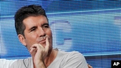 Simon Cowell, a judge on the FOX series "The X Factor," looks on from the stage during a panel discussion on the show at the FOX 2013 Summer TCA press tour at the Beverly Hilton Hotel, Aug. 1, 2013.