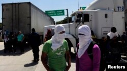 Estudiantes con las caras tapadas bloquean la ruta hacia Acapulco en las afueras de Chilpancingo, estado de Guerrero.
