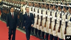 Russian President Dmitry Medvedev, center, with his Chinese counterpart Hu Jintao inspects a guard of honor during a welcoming ceremony at the Great Hall of the People in Beijing Monday, Sept. 27, 2010