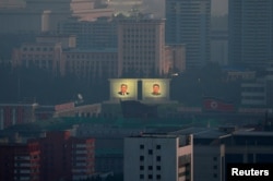 FILE - Portraits of late North Korean leaders Kim Il Sung and Kim Jong Il are seen early morning at a memorial park in Pyongyang, North Korea, Sept. 8, 2018.