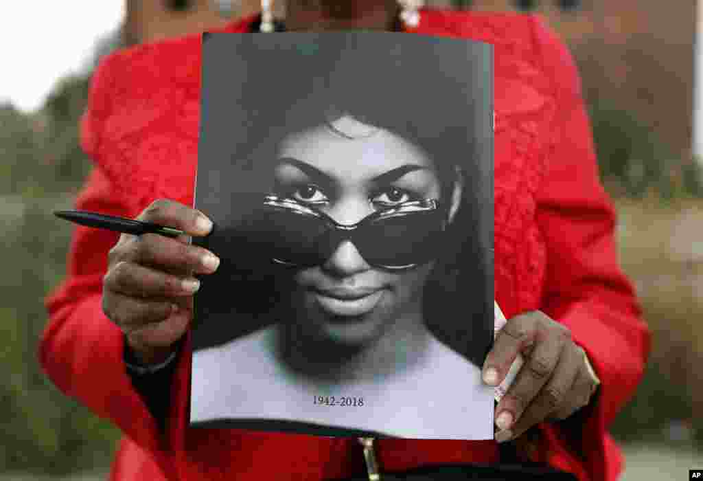 Sharon Napoleon holds a program as she stands outside a viewing for legendary singer Aretha Franklin at New Bethel Baptist Church, Aug. 30, 2018, in Detroit.