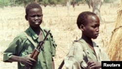 Two Sudanese boy soldiers keep watch outside a rebel military headquarters in remote southern Sudan Feb. 13, 2000. The Sudan People’s Liberation Movement-North (SPLM-N) has agreed to end and prevent the recruitment and use of children in conflict.