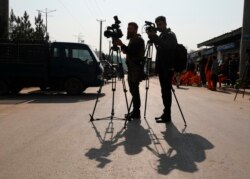 افغان ٹی وی رپورٹرز کابل میں بم دھماکے کے مقام کی فلم بندی کر رہے ہیں۔ 8 فروری 2021
