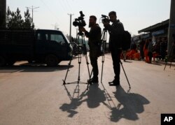 افغان ٹی وی رپورٹرز کابل میں بم دھماکے کے مقام کی فلم بندی کر رہے ہیں۔ 8 فروری 2021