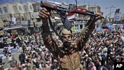 A Yemeni army officer holds up his AK-47 as he and other officers join anti-government protesters demanding the resignation of Yemeni President Ali Abdullah Saleh in Sanaa, Mar 21 2011