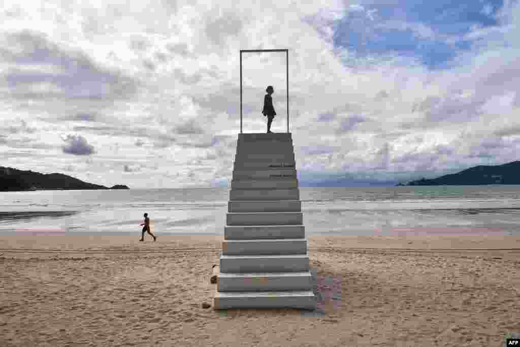 A girl stands on a set of stairs on Patong beach in Phuket, Thailand.